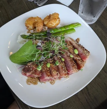 Oscar's plated ahi tuna special with asparagus, rice and greens