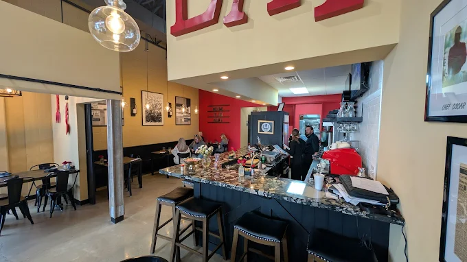 Inside Oscar's bistro: the counter, warm dining room and red EAT sign